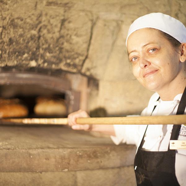 Person putting bread in wood fired oven