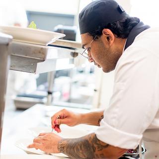 Man in chef's whites working in a kitchen. 