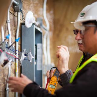 Student and teacher looking at exposed wiring