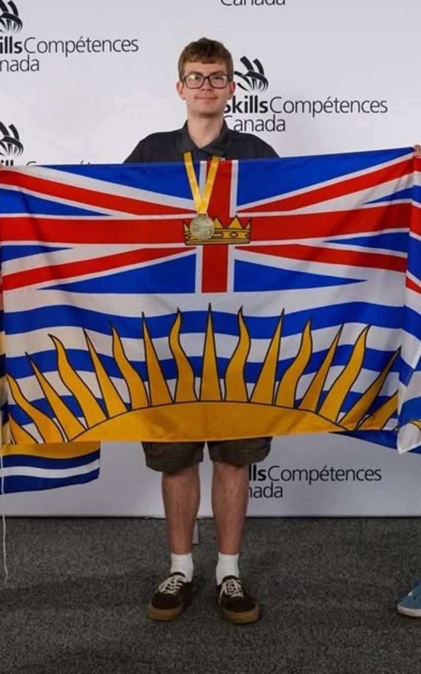 simon with the bc flag after winning gold at skills nationals